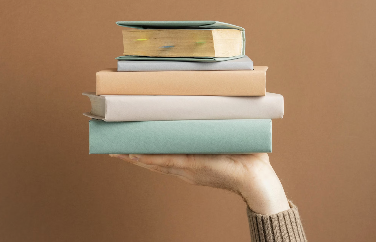 A person holding a stack of books