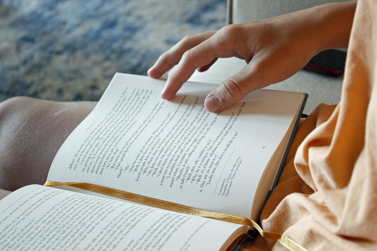 a woman's hand on an open book with lassé