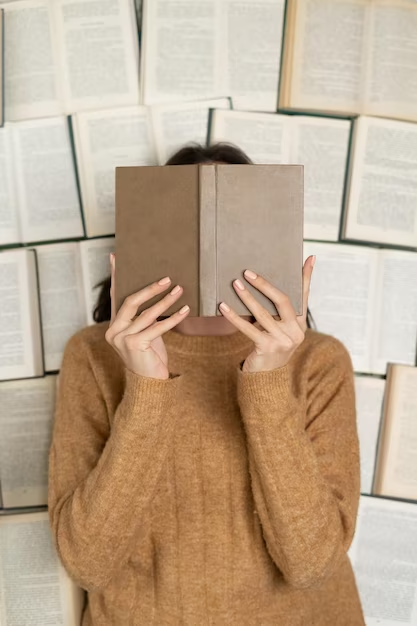 Girl covering her face with a book